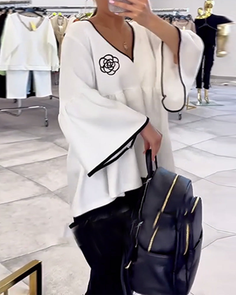 Blusa con scollo a V e maniche svasate in contrasto di colore