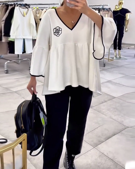 Blusa con scollo a V e maniche svasate in contrasto di colore